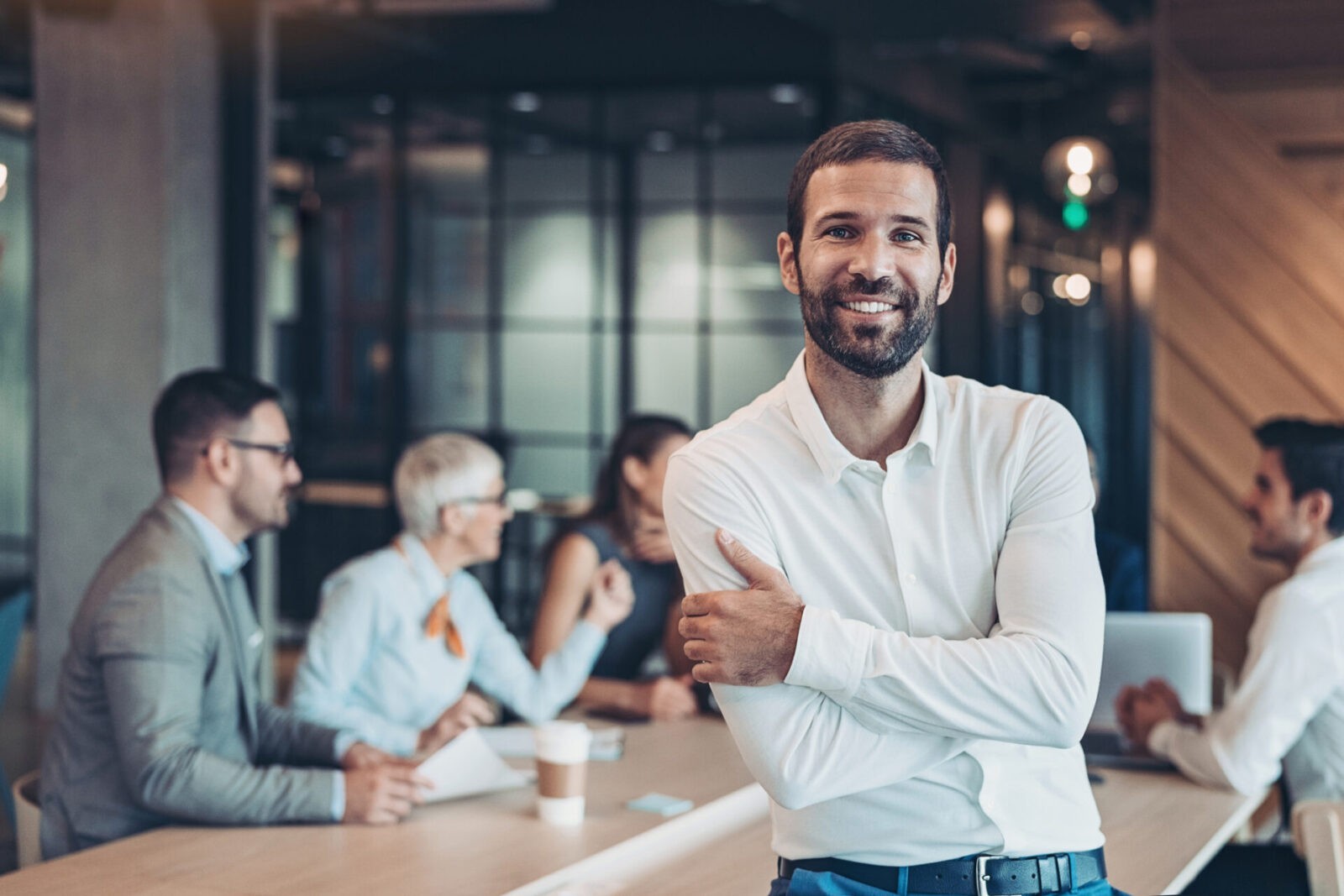 Executive at a meeting with his team behind him