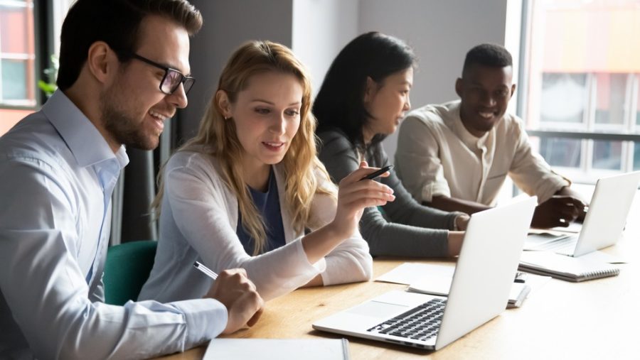 Coworkers discuss around a laptop